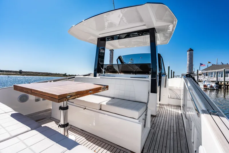 Slide: The Image of The image shows the deck of a 2023 Astondoa 377 Coupe Outboard with a sleek table and seating area. - 40
