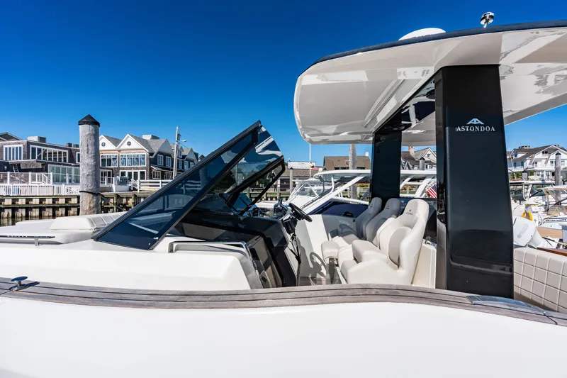 Slide: The Image of The image shows a 2023 Astondoa 377 Coupe Outboard. It is docked in a marina with modern buildings in the background. - 32