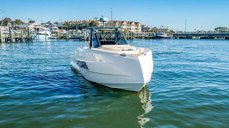 Slide: The Image of The 2023 Astondoa 377 Coupe Outboard glides on calm waters in a harbor with numerous boats. - 19