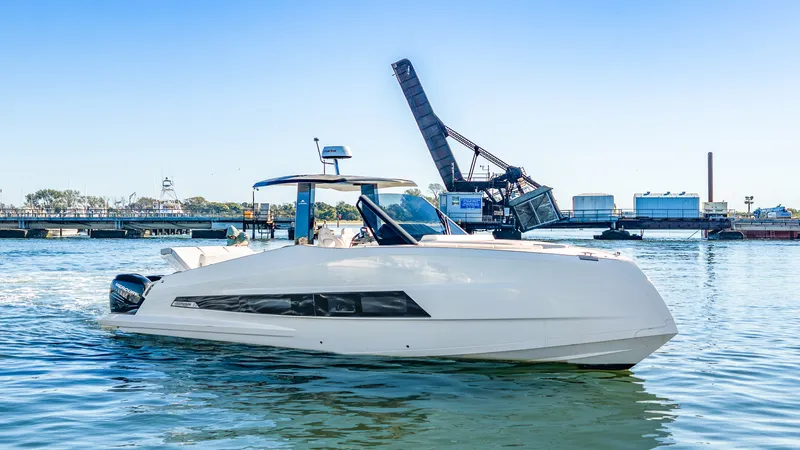 Slide: The Image of The 2023 Astondoa 377 Coupe Outboard cruising on a river with a bridge in the background. - 26