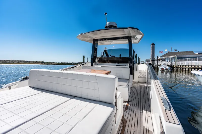 Slide: The Image of The image shows a 2023 Astondoa 377 Coupe Outboard. It is docked with a clear blue sky in the background. - 38