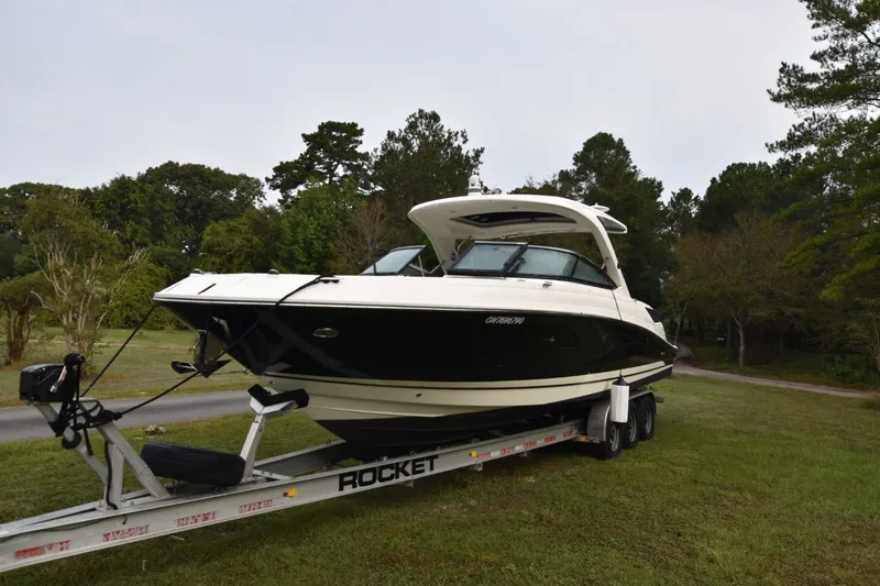Slide: The Image of 2018 Sea Ray SLX 350 boat on trailer, parked on grassy area with trees in background. - 3