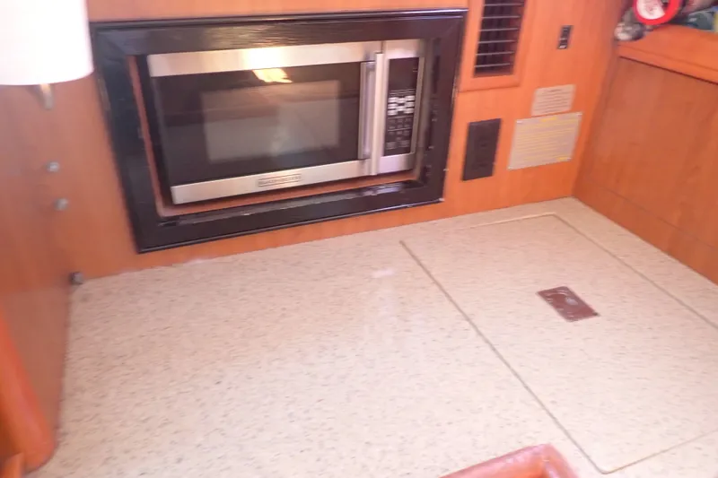 Slide: The Image of Microwave in 2008 Hunter 33 yacht interior, featuring wood paneling and countertop. - 26