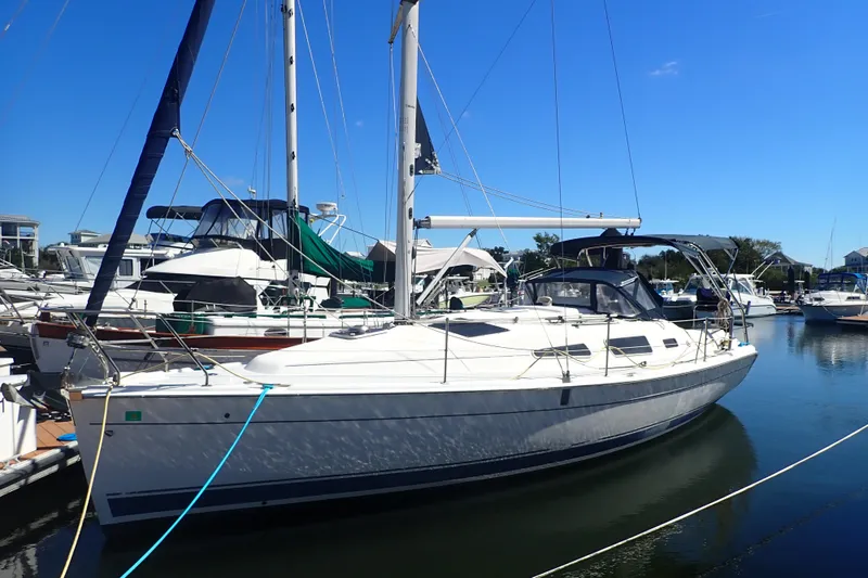 Slide: The Image of 2008 Hunter 33 sailboat docked in a marina under clear blue skies. - 1