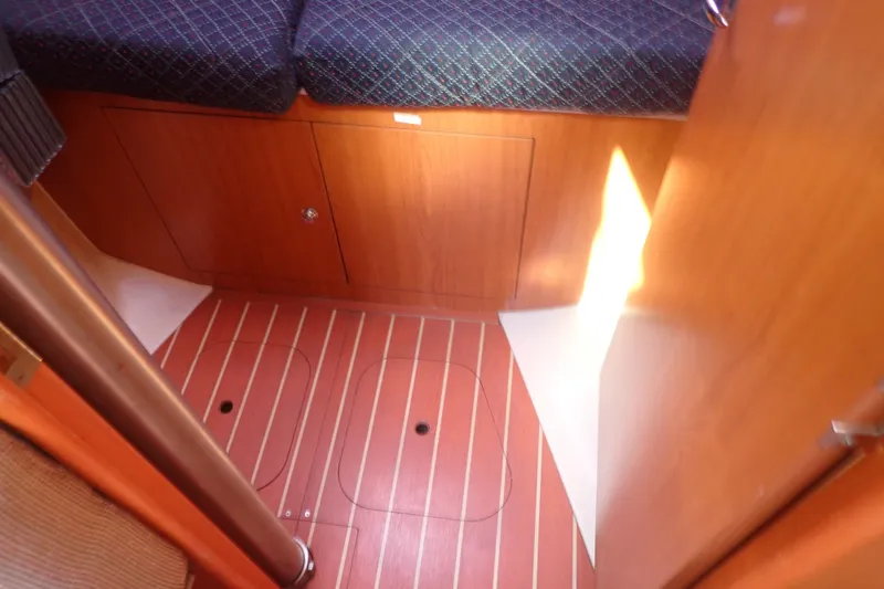 Slide: The Image of Interior of 2008 Hunter 33 sailboat with wooden flooring and storage compartments. - 24