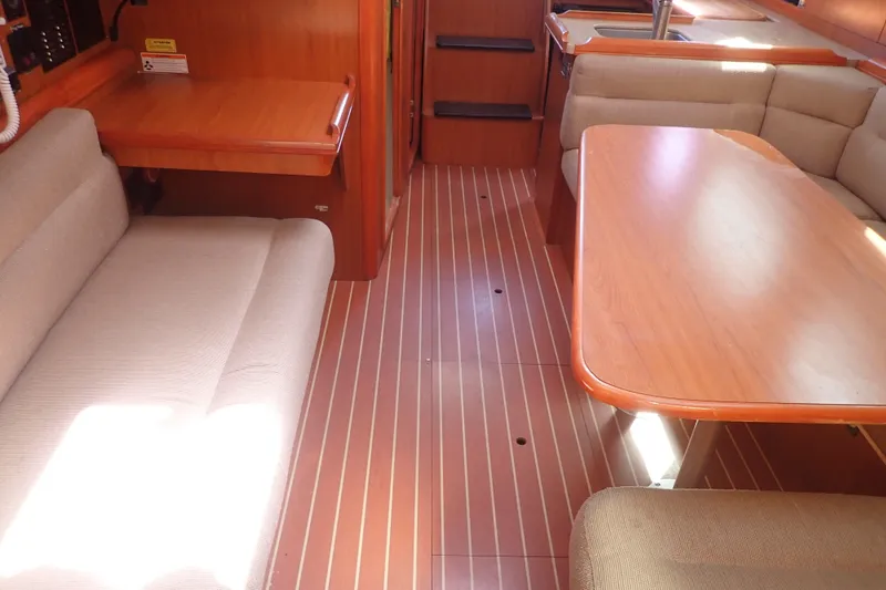 Slide: The Image of Interior of a 2008 Hunter 33 sailboat with wooden flooring and beige seating. - 14