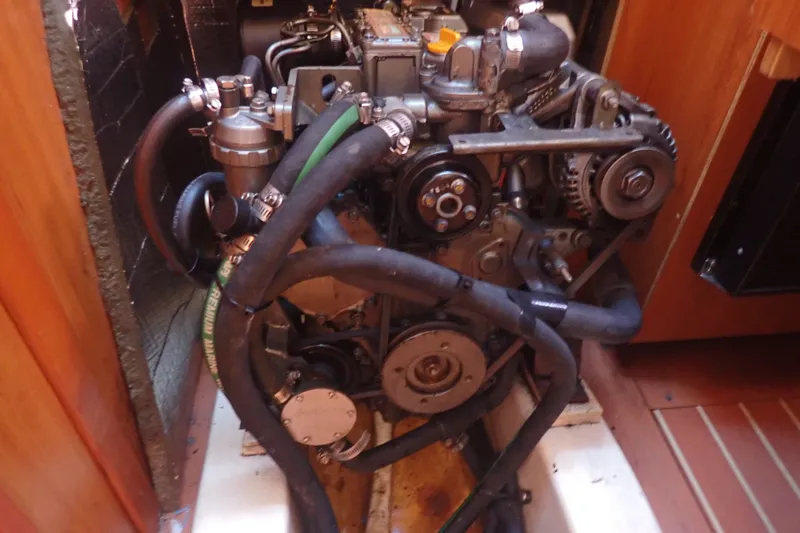 Slide: The Image of Engine compartment of a 2008 Hunter 33 sailboat, showcasing mechanical components and hoses. - 43