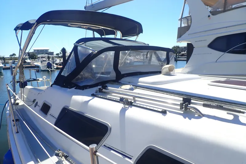 Slide: The Image of 2008 Hunter 33 sailboat docked at marina, featuring sleek design and protective canopy. - 3