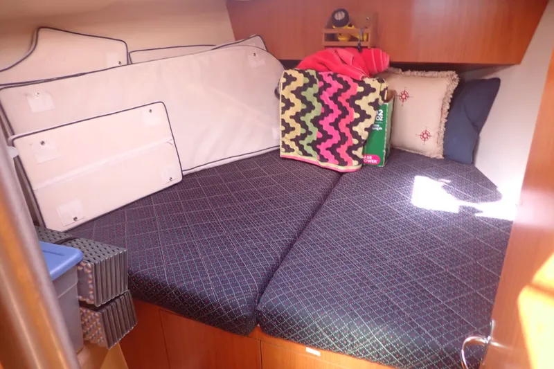 Slide: The Image of Cozy cabin interior of 2008 Hunter 33 sailboat with cushions and colorful blanket. - 22