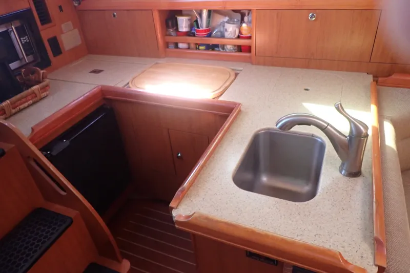 Slide: The Image of Compact kitchen area in a 2008 Hunter 33 sailboat with sink and storage. - 25