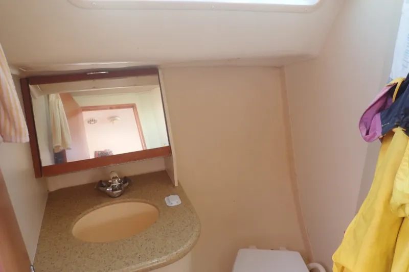 Slide: The Image of Compact bathroom in a 2008 Hunter 33 sailboat with sink, mirror, and storage. - 34