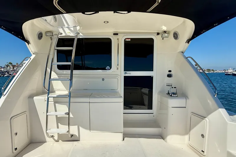 Slide: The Image of 2006 Riviera 40 Flybridge yacht stern view with ladder and ocean backdrop. - 57