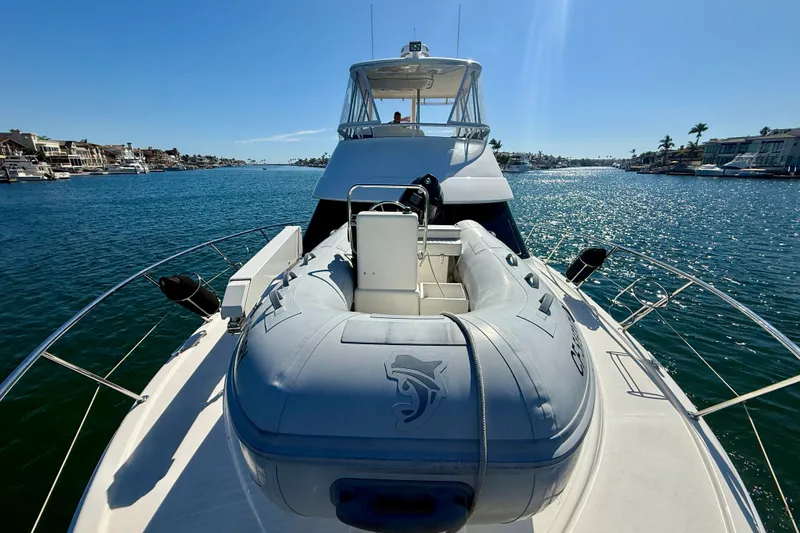 Slide: The Image of 2006 Riviera 40 Flybridge yacht with inflatable boat on deck, cruising in sunny waters. - 70