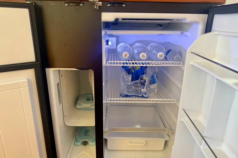 Slide: The Image of Open refrigerator on a 2006 Riviera 40 Flybridge, stocked with water bottles and ice packs. - 37
