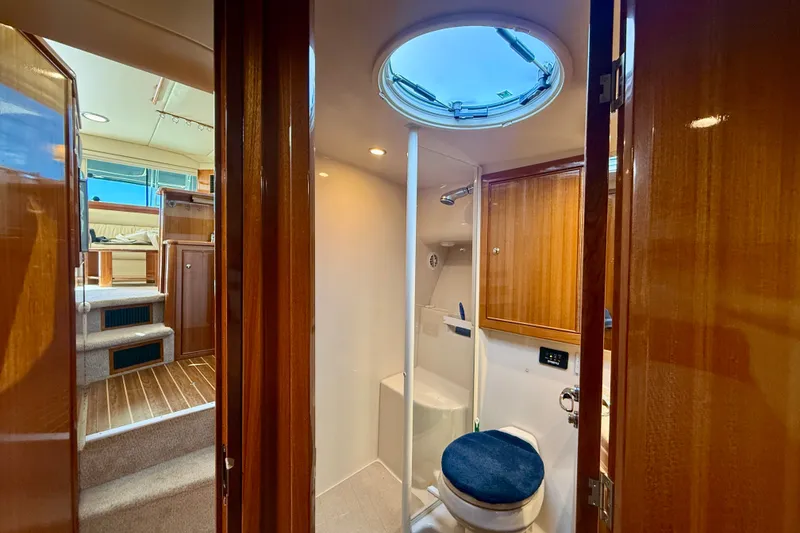 Slide: The Image of Interior of 2006 Riviera 40 Flybridge yacht, featuring a compact bathroom and wooden cabinetry. - 50