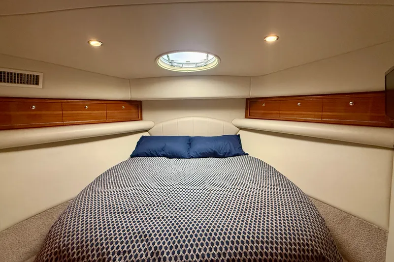 Slide: The Image of Luxurious 2006 Riviera 40 Flybridge yacht bedroom with elegant bedding and wood accents. - 41