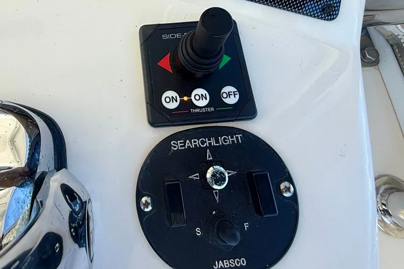 Slide: The Image of Control panel of a 2006 Riviera 40 Flybridge with thruster and searchlight switches. - 83