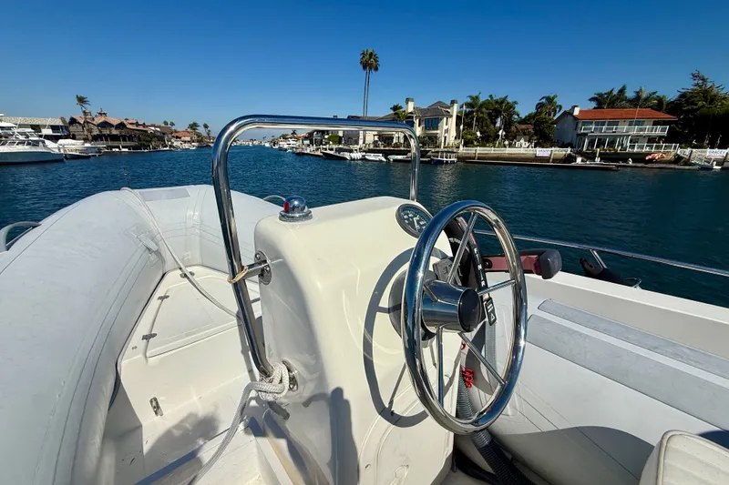 Slide: The Image of Steering wheel of a 2006 Riviera 40 Flybridge boat on a sunny waterfront. - 68