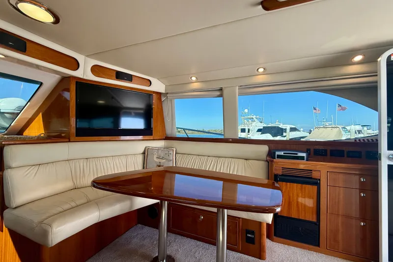 Slide: The Image of Luxurious interior of 2006 Riviera 40 Flybridge yacht with leather seating and wooden table. - 22