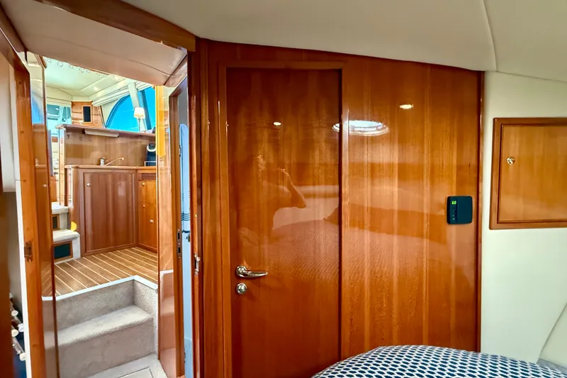 Slide: The Image of Interior of 2006 Riviera 40 Flybridge yacht, featuring polished wood paneling and cozy cabin space. - 46