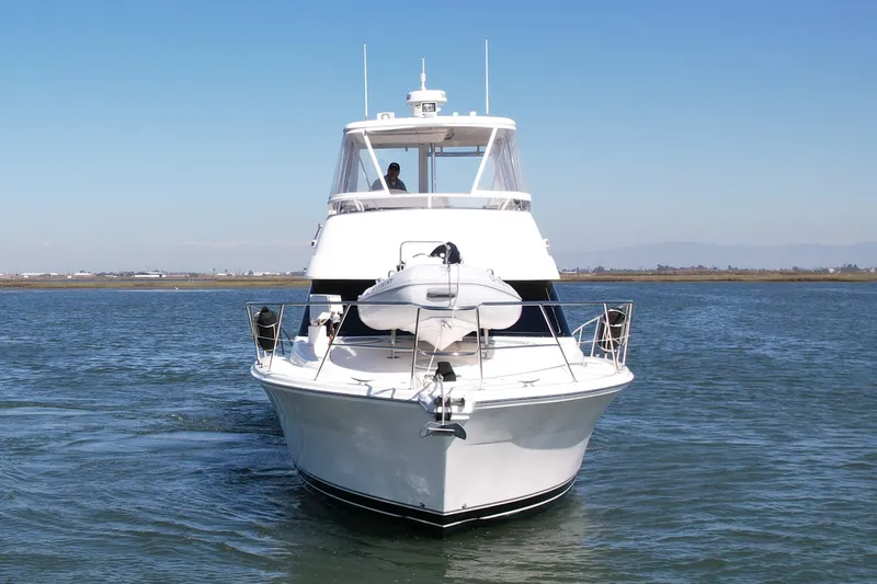 Slide: The Image of 2006 Riviera 40 Flybridge yacht cruising on open water under clear skies. - 1