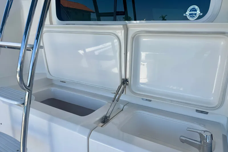 Slide: The Image of 2006 Riviera 40 Flybridge yacht sink and storage area with open lids and chrome ladder. - 60
