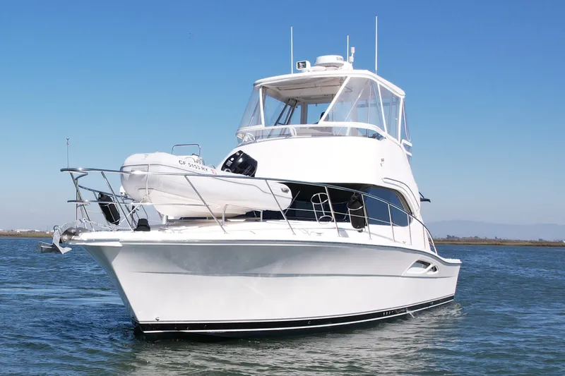 Slide: The Image of 2006 Riviera 40 Flybridge yacht on calm water under clear blue sky. - 6