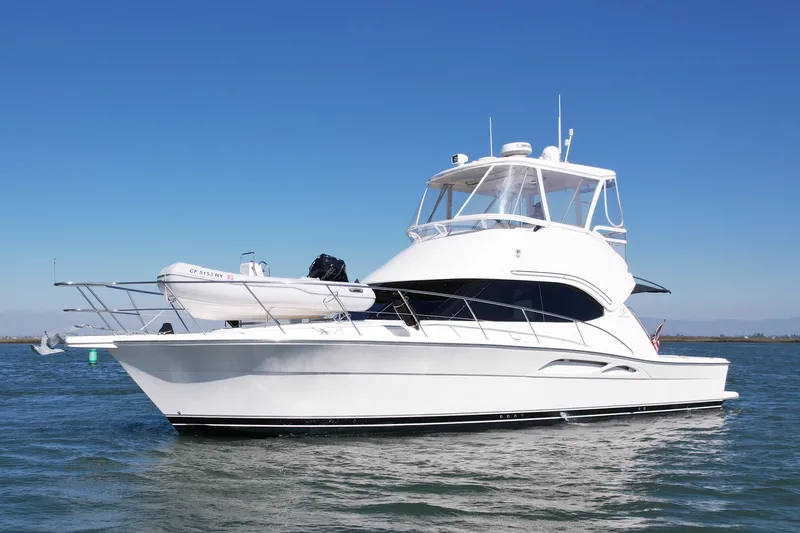 Slide: The Image of 2006 Riviera 40 Flybridge yacht on calm waters under clear blue sky. - 3