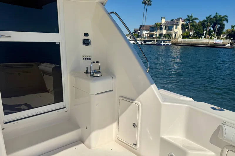 Slide: The Image of 2006 Riviera 40 Flybridge yacht deck with sink, overlooking waterfront homes and palm trees. - 59
