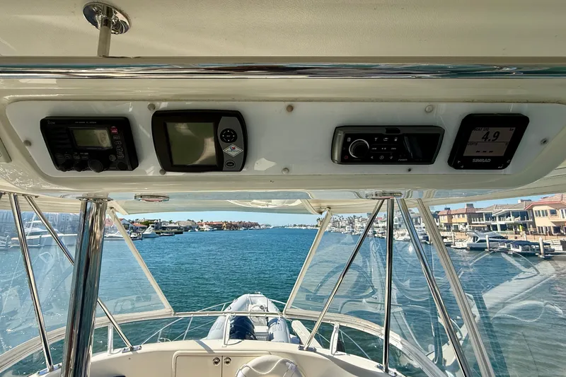 Slide: The Image of 2006 Riviera 40 Flybridge cockpit view with navigation instruments and waterfront scenery. - 89