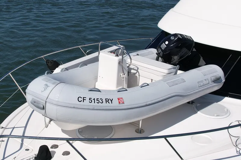 Slide: The Image of Inflatable boat on 2006 Riviera 40 Flybridge yacht, docked on calm water. - 7