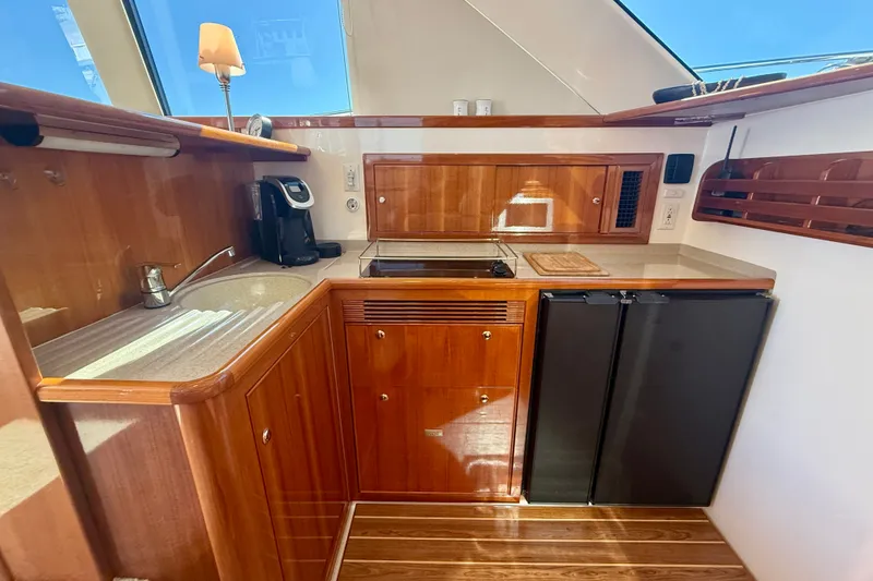 Slide: The Image of Luxurious 2006 Riviera 40 Flybridge yacht kitchen with wood cabinetry and modern appliances. - 24