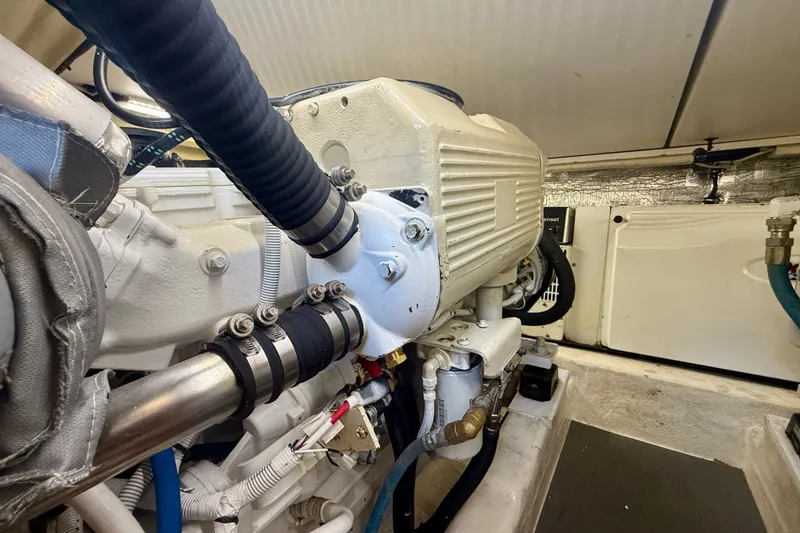 Slide: The Image of Engine room of a 2006 Riviera 40 Flybridge yacht, showcasing mechanical components and piping. - 97