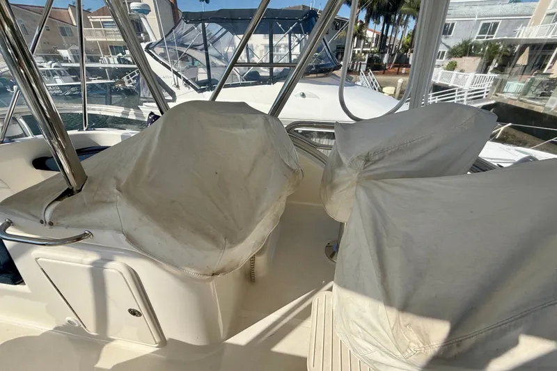 Slide: The Image of 2006 Riviera 40 Flybridge interior with covered seats and marina view. - 90