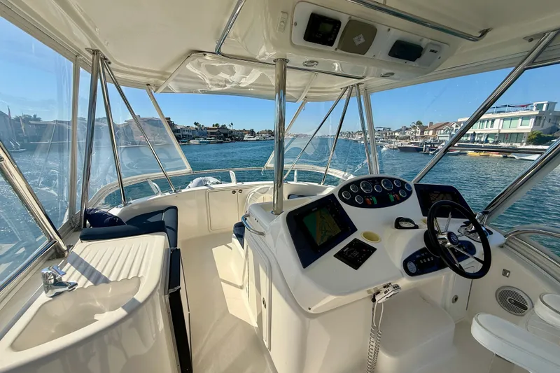 Slide: The Image of Interior view of 2006 Riviera 40 Flybridge yacht, showcasing helm and waterfront scenery. - 76