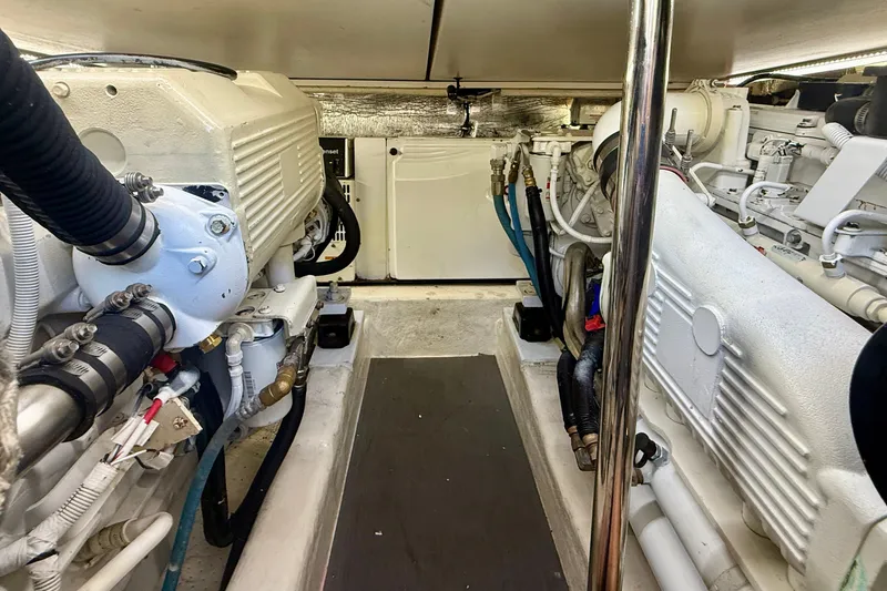 Slide: The Image of Engine room of a 2006 Riviera 40 Flybridge yacht, showcasing dual engines and mechanical components. - 94