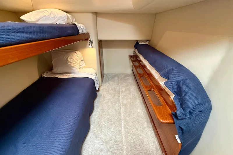 Slide: The Image of 2006 Riviera 40 Flybridge cabin with cozy bunk beds and blue bedding. - 54