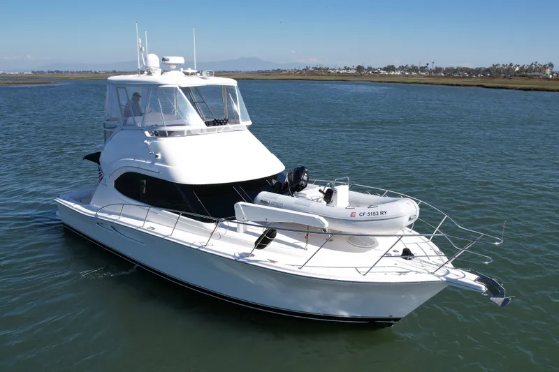 Slide: The Image of 2006 Riviera 40 Flybridge yacht on calm water, featuring sleek design and upper deck. - 8