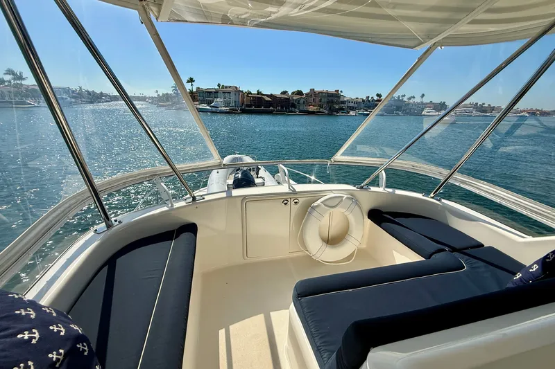 Slide: The Image of Flybridge view from 2006 Riviera 40, overlooking serene waterfront and luxury homes. - 74