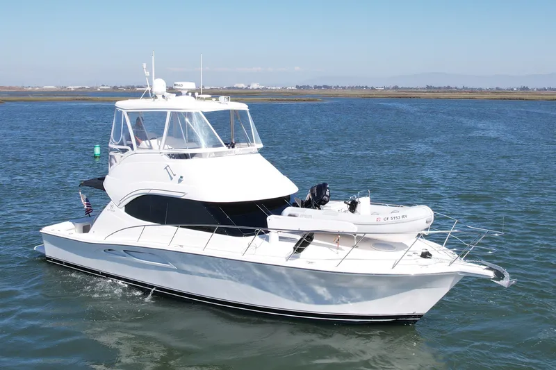 Slide: The Image of 2006 Riviera 40 Flybridge yacht cruising on open water under clear skies. - 5