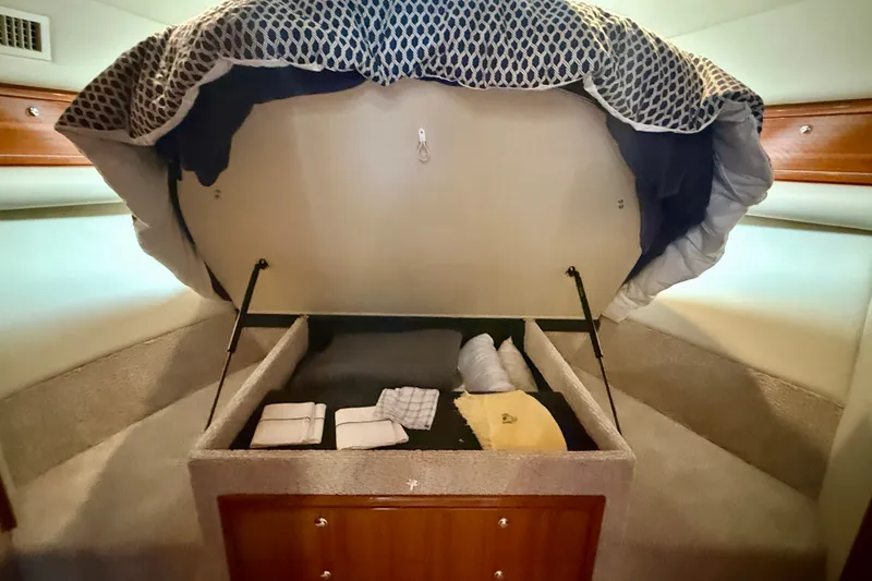 Slide: The Image of 2006 Riviera 40 Flybridge yacht bedroom with under-bed storage, neatly organized linens. - 43