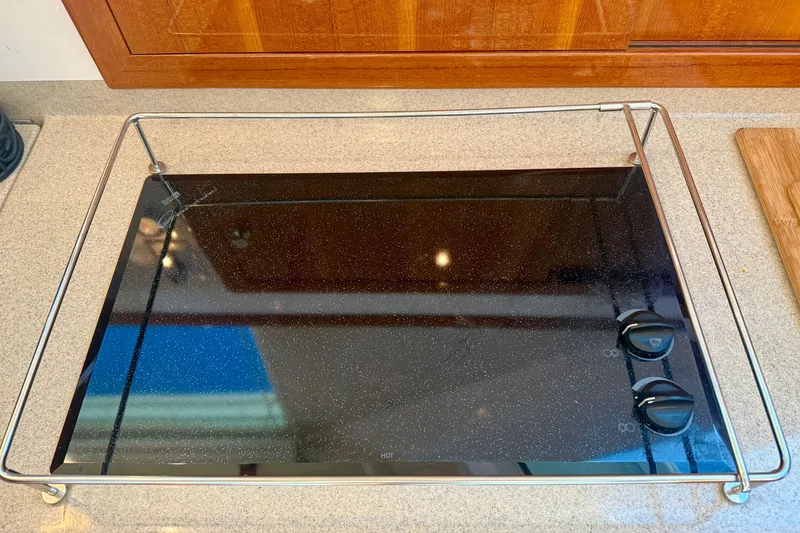 Slide: The Image of Glass cooktop on 2006 Riviera 40 Flybridge yacht, featuring sleek design and control knobs. - 27