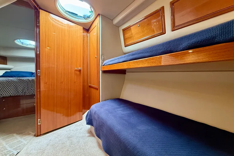 Slide: The Image of Interior of 2006 Riviera 40 Flybridge yacht with wooden finishes and cozy bunk beds. - 55