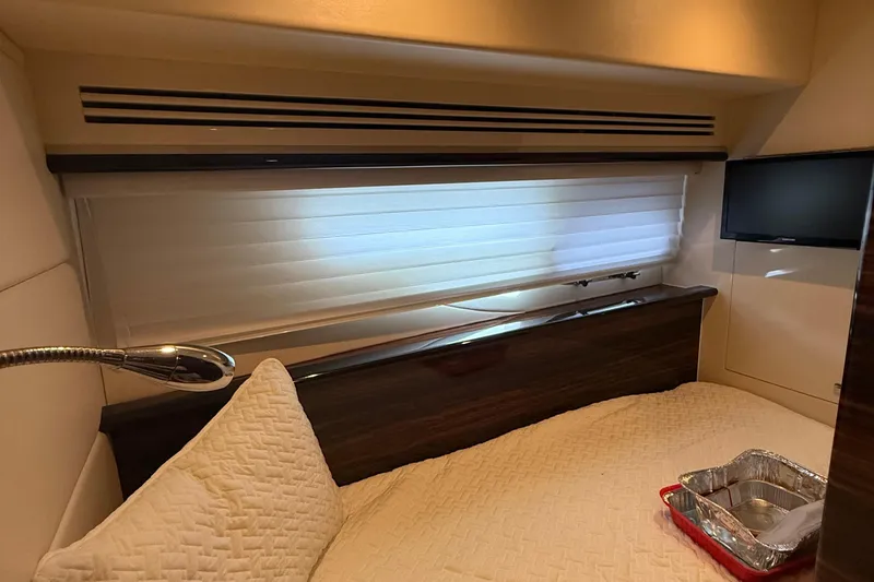 Slide: The Image of Interior of a 2014 Hampton Fly yacht bedroom with modern decor and a small TV. - 28