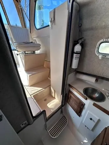 Slide: The Image of Interior of 1999 Atlas Boat Works Acadia 25, featuring seating, sink, and fire extinguisher. - 15