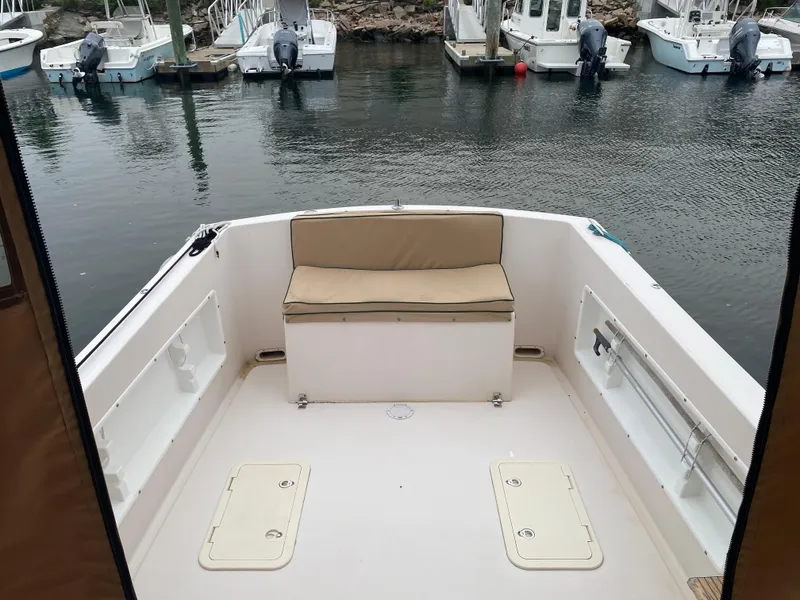 Slide: The Image of 1999 Atlas Boat Works Acadia 25, spacious deck with seating, docked in marina. - 13