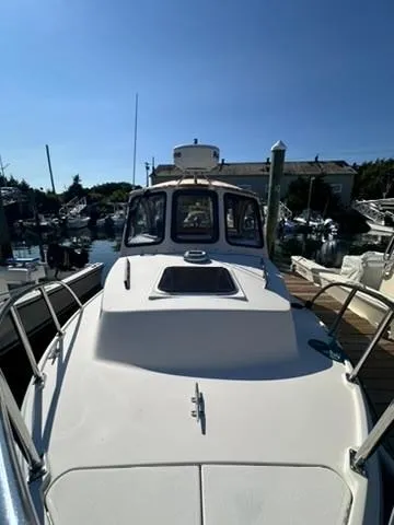 Slide: The Image of 1999 Atlas Boat Works Acadia 25 docked in a marina under clear blue skies. - 6
