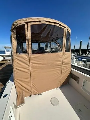 Slide: The Image of 1999 Atlas Boat Works Acadia 25 with tan canvas enclosure at dock. - 7