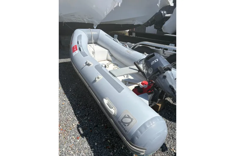 Slide: The Image of 2016 Zodiac Cadet RIB 340 PVC inflatable boat with outboard motor on gravel. - 1
