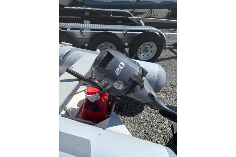 Slide: The Image of 2016 Zodiac Cadet RIB 340 PVC with 20 HP outboard motor, parked on gravel. - 2